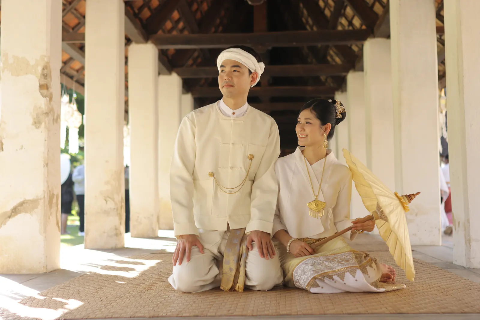 คู่บ่าวสาวนั่งในระเบียงวิหาร แสงแดดส่องผ่านเสา